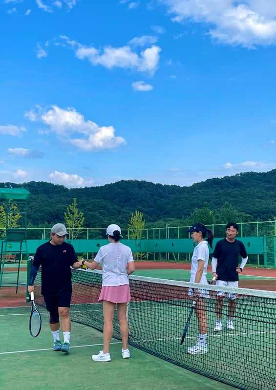 테니스 코트에서 운동하는 회원들